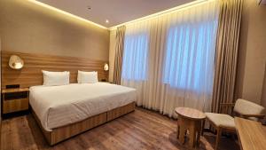 a hotel room with a bed and a table and chairs at Hotel Bankir Khiva in Khiva