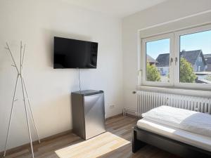 una camera da letto con un letto e una televisione a parete di Meribu W18-20 Wohnung für Monteure und Arbeiter a Bottrop