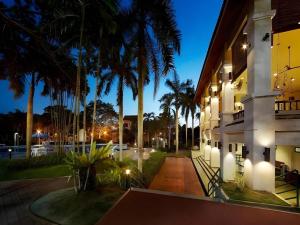 a night view of a building with palm trees at Swiss Court Holiday Apartments in Lumut