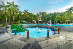 a pool with a slide and swans in a resort at Swiss Court Holiday Apartments in Lumut