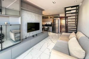a living room with a couch and a television at Duplex Super Charmoso 200m Praia Bessa 3 Pessoas in Nossa Senhora do Livramento