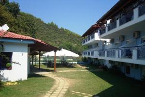 a building with a pathway next to a mountain at Asterias Hotel in Porto Koufo