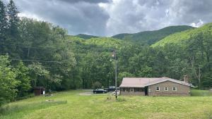 a house in the middle of a field next to a mountain at CampRV Main Lodge in Elkins