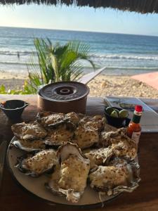 a plate of oysters on a table next to the beach at Penthouse Vallarta in Puerto Vallarta