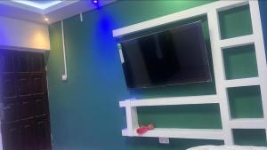 a flat screen tv on a blue wall in a room at Mountains View Villa in Freetown