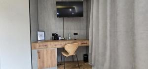 GłogówekKaMi Self check-in 24 h的一张桌子、一把椅子和一台挂在墙上的电视 更多33张照片