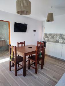 a kitchen and dining room with a wooden table and chairs at El Alfarero de Maimará - Cabaña Álamo in Maimará