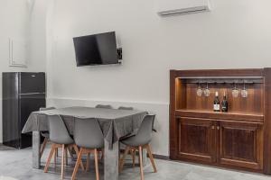a dining room with a table with chairs and a television at Delia home service in Fiumefreddo di Sicilia