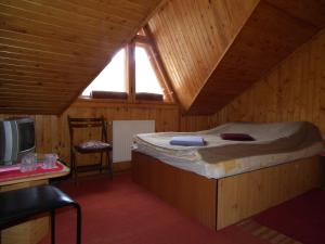 a bedroom with a bed in a wooden room at Pensiunea Ando in Bran