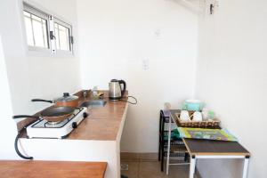a kitchen with a stove and a counter top at Departamento Novos Apart Catamarca Alquiler temporario in San Fernando del Valle de Catamarca +17 photos