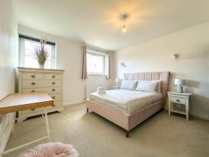 a bedroom with a pink bed and a dresser at Modern 3 Bed Home - Pets Welcome - FREE Parking in Canterbury