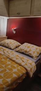a bed with a yellow and white comforter in a bedroom at Hiška La Vita Kamp Terme 3000 Moravske Toplice vključeno 3x KOLO Športni rekviziti, Igrače in Moravske Toplice