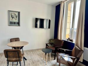a room with a table and chairs and a window at Le studio Vintage du centre ville - Proche coeur historique in Bergerac +1 photo