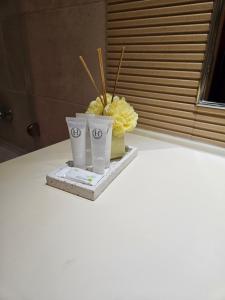 two cups sitting on a table with yellow flowers at Love Room- Adult Only in Bucharest
