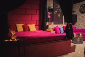 a room with a bed with pink sheets and pillows at WELLNESS privátní - Brno in Lískovec