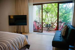 Higuera BlancaにあるDepartamento en Litibu Punta Mitaのベッドとテレビとバルコニーのある寝室