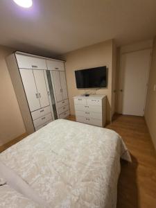 a bedroom with a bed and a flat screen tv at Minidepartamento en Ñaña in Chosica +27 photos