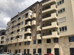 an apartment building with cars parked in front of it at M&M Cozy Apartment-Free Parking in Skopje