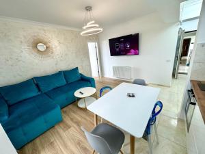 Una sala de estar con un sofá azul y una mesa. en Solid Residence Melody, en Mamaia 34 fotos más