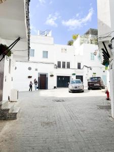 two people standing in front of a white building at Chez Hasnae Studio - Heart of Medina, Close to Sea in Tangier