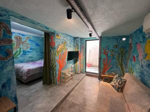a room with colorful walls and a bedroom with a bed at Ayşem Mill Hill Houses in Bodrum City