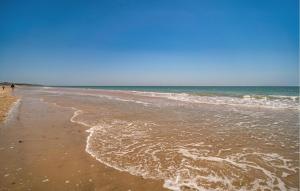 a sandy beach with waves coming in from the ocean at Stunning Home In Chiclana De La Fronter in Chiclana de la Frontera +12 photos