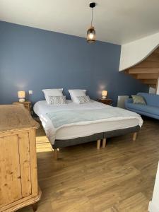 a bedroom with a bed and a blue wall at Plein centre Auray - Grand duplex 2 chambres avec terrasse ensoleillée in Auray