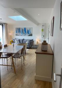 a living room with a table and a couch at Plein centre Auray - Grand duplex 2 chambres avec terrasse ensoleillée in Auray