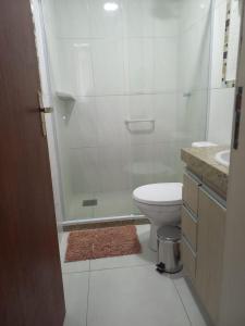 a bathroom with a shower and a toilet and a sink at Suíte com Pé na Areia, Praia dos anjos in Arraial do Cabo