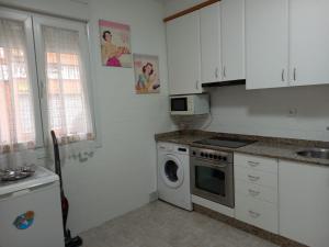 una cocina con estufa y lavadora en Casa "O Forte" en la playa, Espectacular ubicación, en Cangas de Morrazo