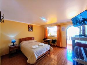 a bedroom with a bed and a flat screen tv at La Finca Tarma in Tarma
