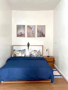 a bedroom with a blue bed with four pictures on the wall at Casamigos Cosy one bedroom appartment in Dakar