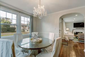 ein Esszimmer mit einem Glastisch und weißen Stühlen in der Unterkunft Happy Coastal Cottage for 6 in Jacksonville