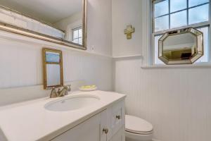 ein Badezimmer mit Waschbecken, Toilette und Spiegel in der Unterkunft Happy Coastal Cottage for 6 in Jacksonville + 32 Fotos