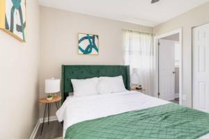 a bed with a green headboard in a bedroom at UnWind Bungalow for 6 in Jacksonville