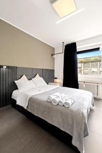 a bedroom with a large bed with towels on it at Smart City Apartment in Bestlage! self check-in, Neu! in Cologne