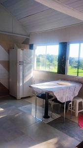 a kitchen with a table and a refrigerator at Chalé Paiano in Rio do Sul