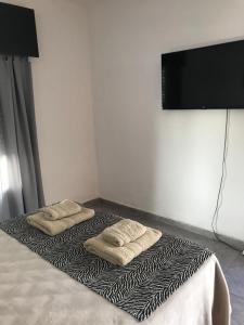 ein Zimmer mit einem Bett mit zwei Handtüchern darauf in der Unterkunft Lo de Nina in Villa María