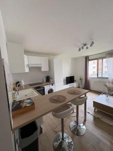 Una cocina con una mesa y sillas en una habitación. en Charmant T2 rénové, en Lyon 3 fotos más