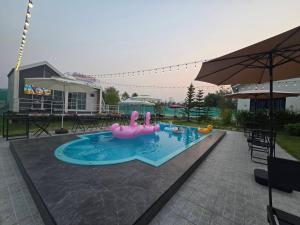 a swimming pool with a pink inflatable flamingos in it at Chaba 4 family in Nakhon Nayok