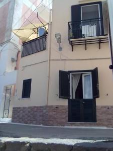 a building with a door and a balcony at Appartamento nel porto da Silveria in Ponza