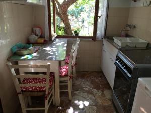 eine Küche mit einem Waschbecken und einem Tisch mit Stühlen in der Unterkunft Casa Tra Il Verde E Il Blu in Genua