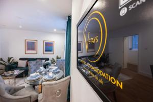 a living room with a table and a sign on a wall at Temple Chambers Aparthotel Central Croydon , Long Stays , Weekly & Monthly Offers , Contractors , Relocations , Leisure & Family Stays in Croydon