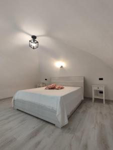 a white bedroom with a bed and a light on the ceiling at "Antica Dimora" - Appartamenti Turistici Nuovi a Gravina in Puglia - con Parcheggio Gratuito su Strada in Gravina in Puglia