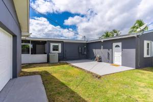 a gray house with a yard in front of it at Centrally located Family-business Home in Homestead
