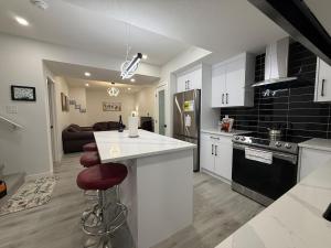 a kitchen with a white counter top and a stove at Maxti Guest Suite, Northwest Calgary in YYC