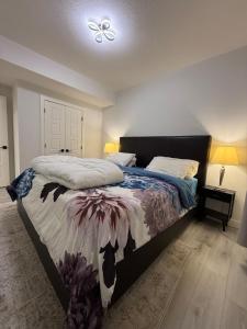 a bedroom with a bed with a comforter on it at Maxti Guest Suite, Northwest Calgary in YYC