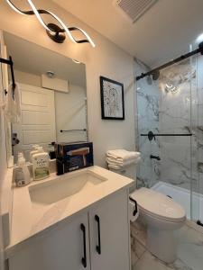 a bathroom with a sink and a toilet and a shower at Maxti Guest Suite, Northwest Calgary in YYC