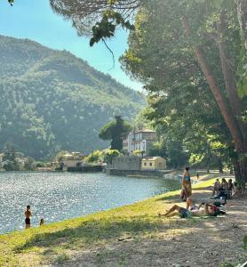 a group of people laying on the grass near a lake at La sosta al lago in Londa