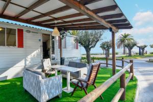 新马尔马拉斯Camping Castello的凉亭下有桌椅的露台